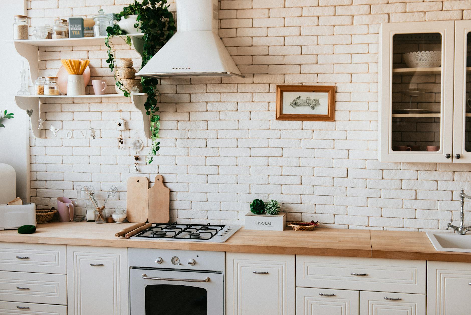 Kitchen with white cabinets and wood counters.  Clean and set up for meal prepping
