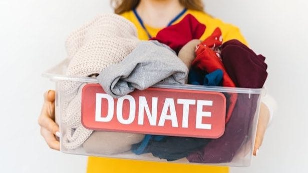 clear tote with clothes in box and sign on front that says donate