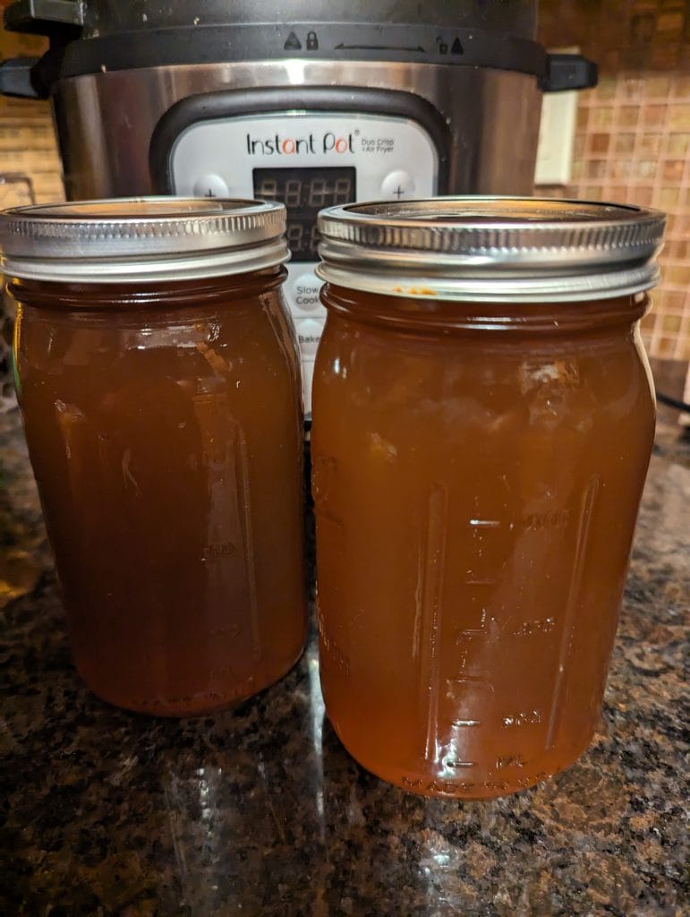 photograph of homesteading homemade bone broth in mason jars with instant pot in background