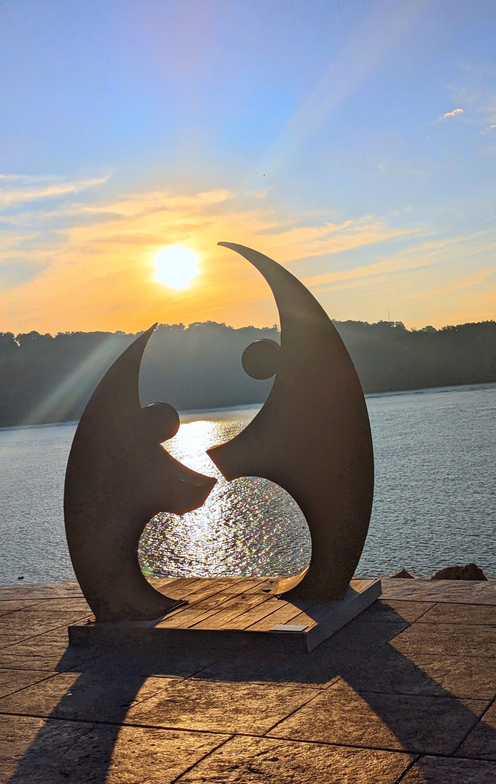 statue of two people holding the sun