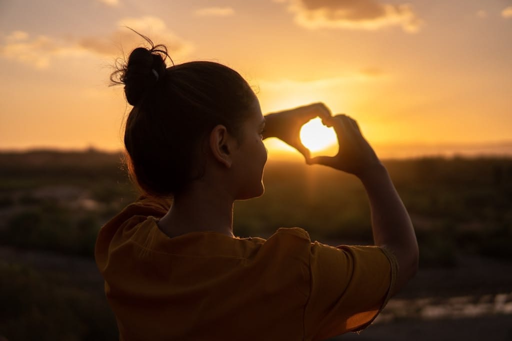 Woman Doing Hand Heart Sign. practicing self-care tips
