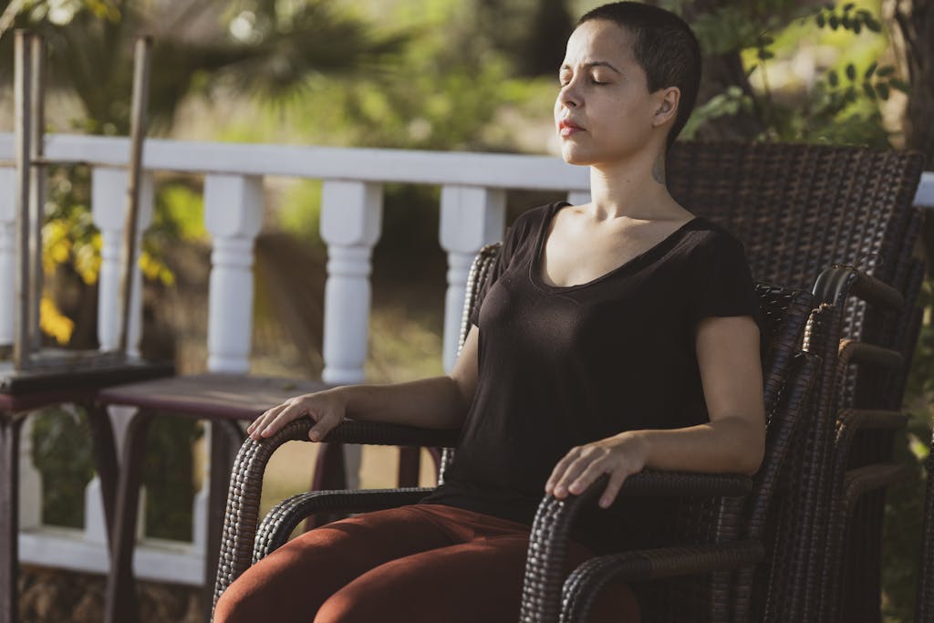 Woman in Black Top Sitting on Brown Armchair - Breathing exercise for balance hormones naturally