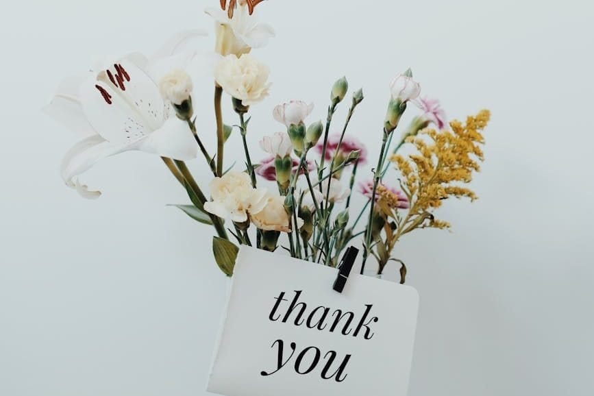 bunch of flowers with a postcard that says thank you