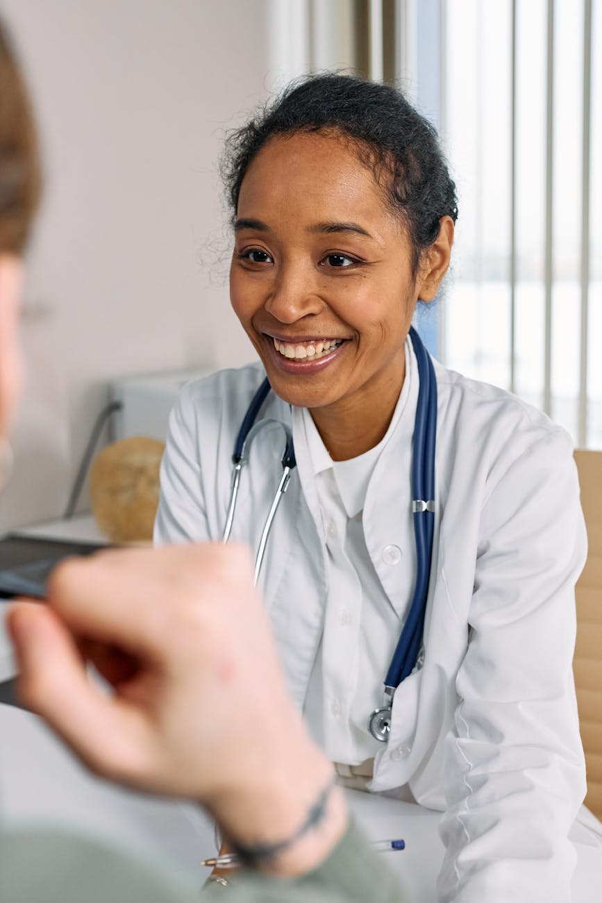 portrait of a doctor smiling. Woman talking to doctor about signs of burnout