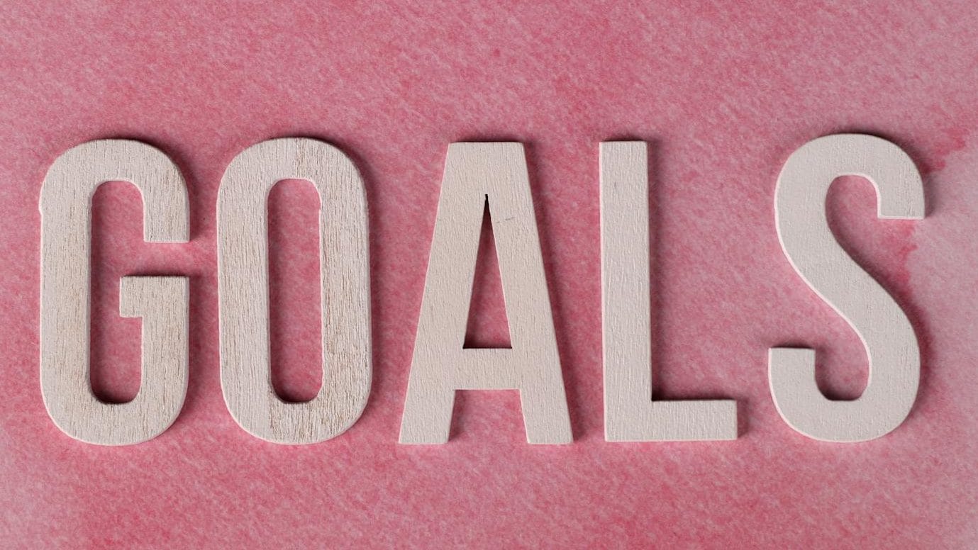 inspiring pink goals text on watercolor background