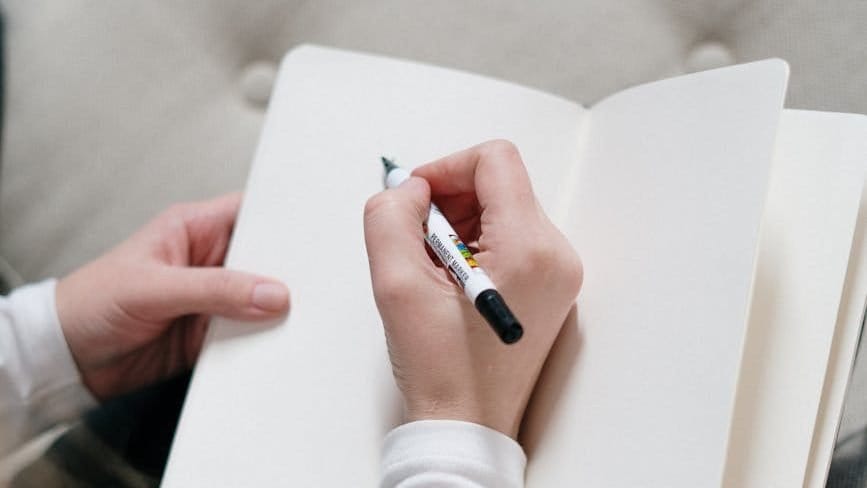 person writing on a notebook